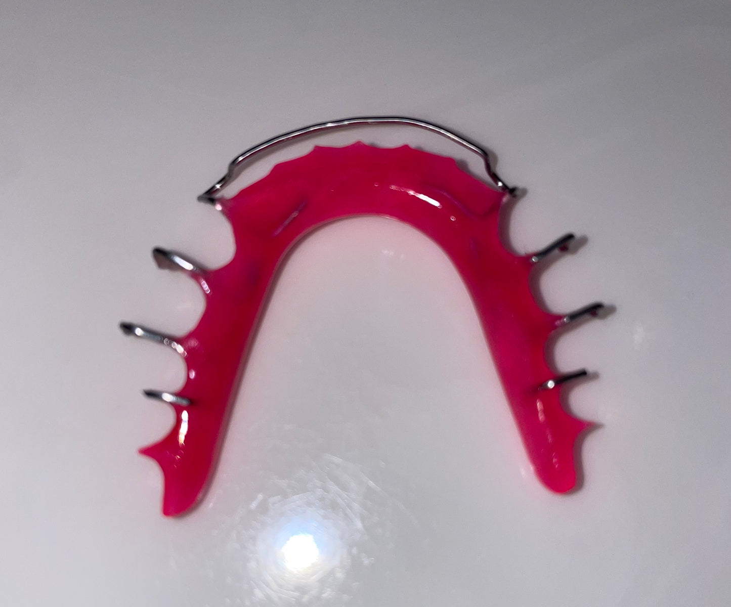 Lower Hot pink Hawley Retainer. Hawley retainer is used to retain teeth. 